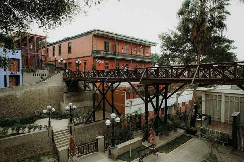 A pedestrian bridge, a red building, and a palm tree. 3