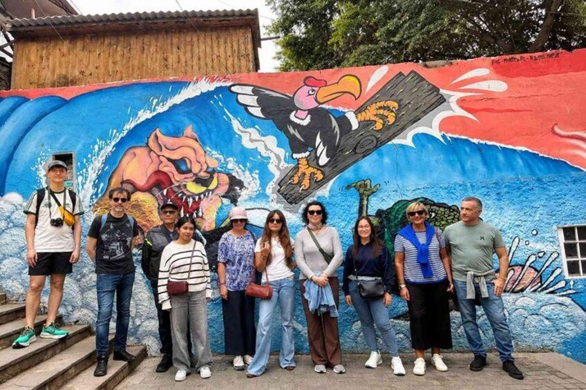 A mural with a large bird and a roaring animal, people standing in front of it. 4