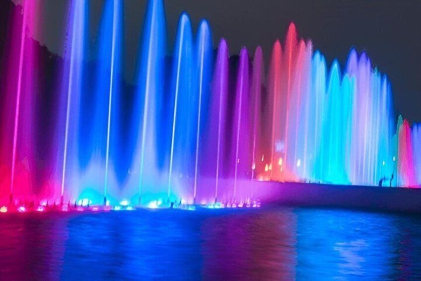 A nighttime fountain display with multiple water jets illuminated in various colors. 3