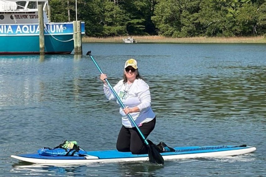 A person on a paddleboard in a body of water with a boat named 'ATLANTIC EXPLORER' in the background. 5