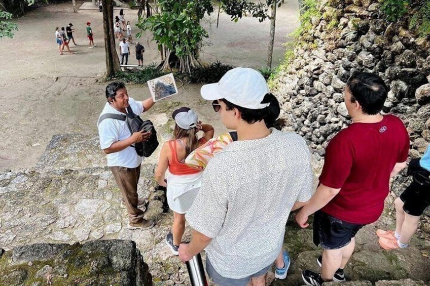 A group of people standing on a stone path, some holding maps or guides. 5