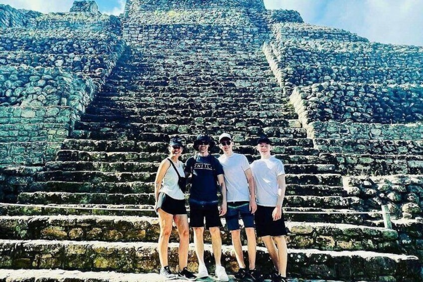 A group of people standing in front of a large stone staircase leading up to a pyramid. 3