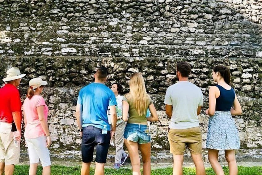 A group of people standing in front of a stone wall. 1