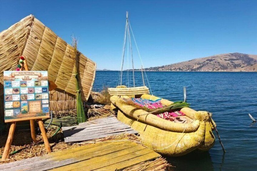 A traditional boat docked at a wooden pier with a thatched roof structure nearby. 2