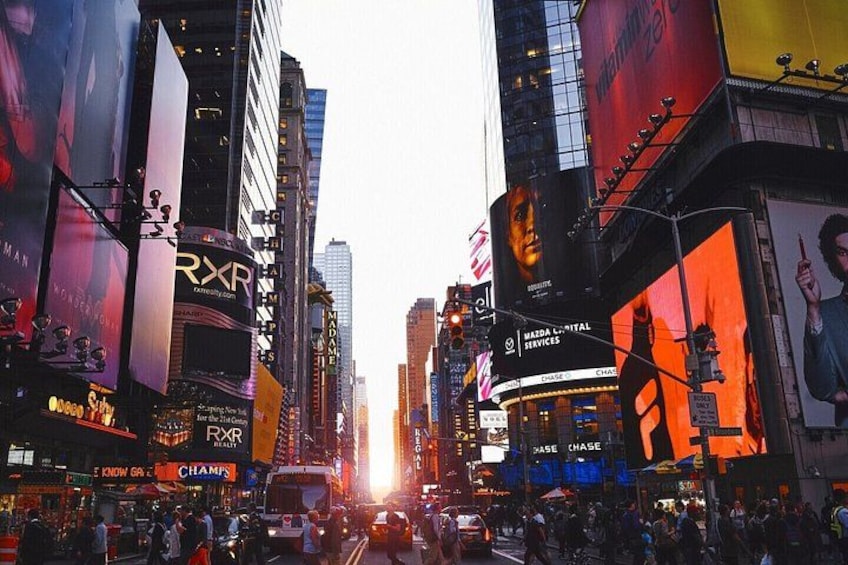 A busy urban street with tall buildings, billboards, and a crowd of people. 4