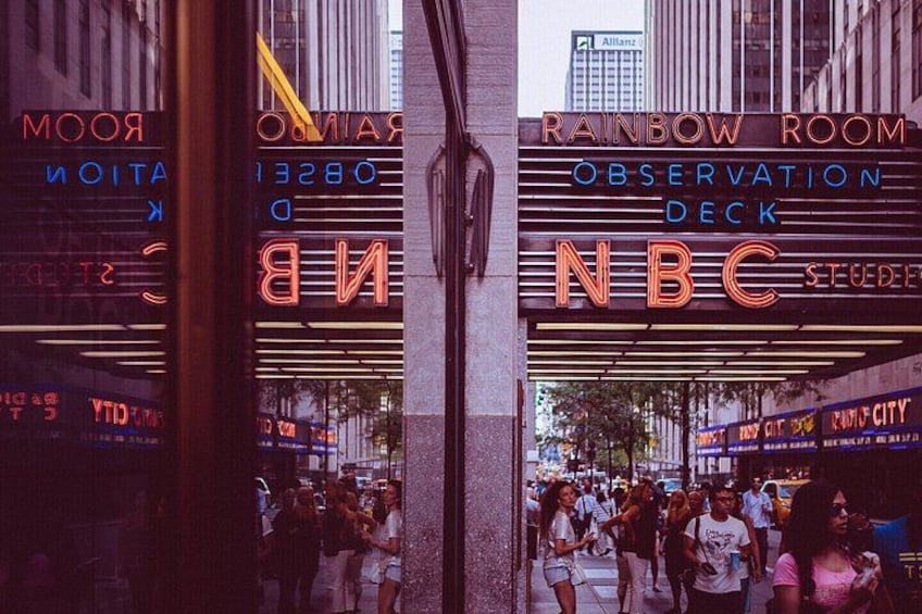 A street with a neon sign for NBC and a Rainbow Room. 3