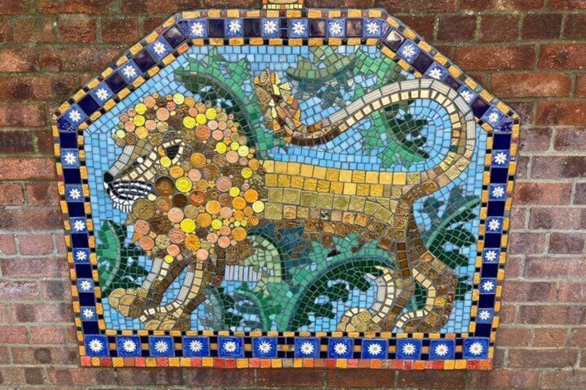 A mosaic of a lion on a brick wall. 4
