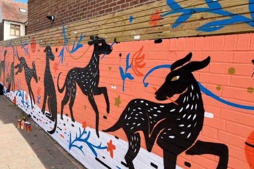 A mural of kangaroos on a brick wall. 5