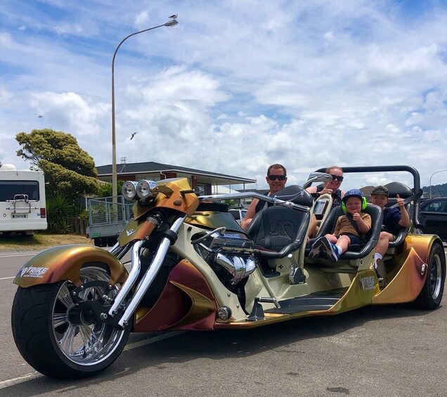 A motorcycle with a sidecar, people riding it, and a trailer in the background. 2