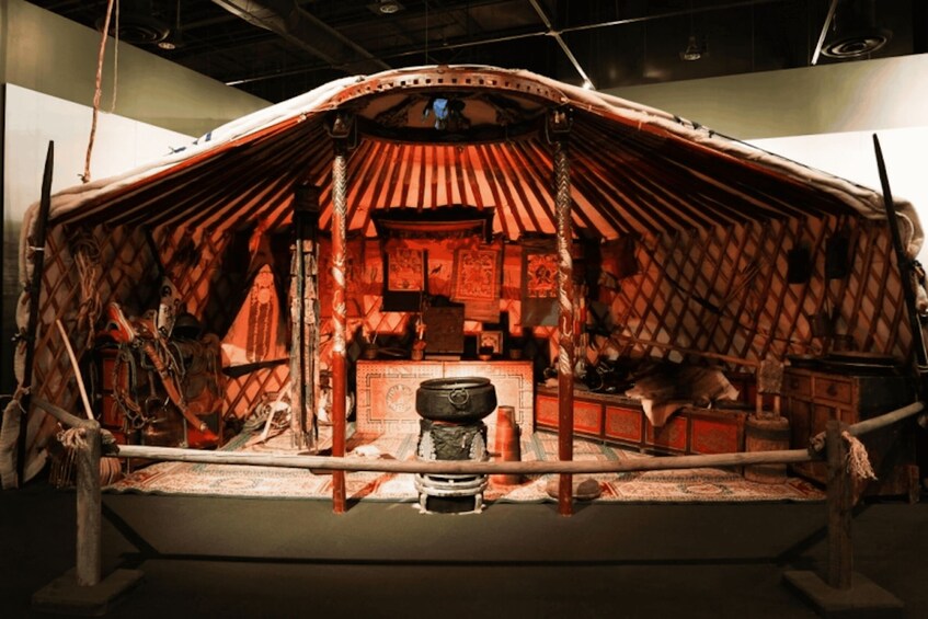A traditional yurt with a wooden frame, a thatched roof, and a central hearth. 5