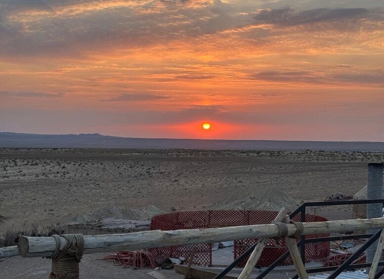 Solnedgang over et ørkenlandskab med en byggeplads i forgrunden. 5