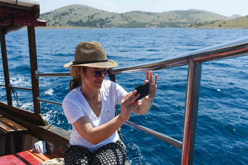 A person on a boat taking a photo with a smartphone. 3