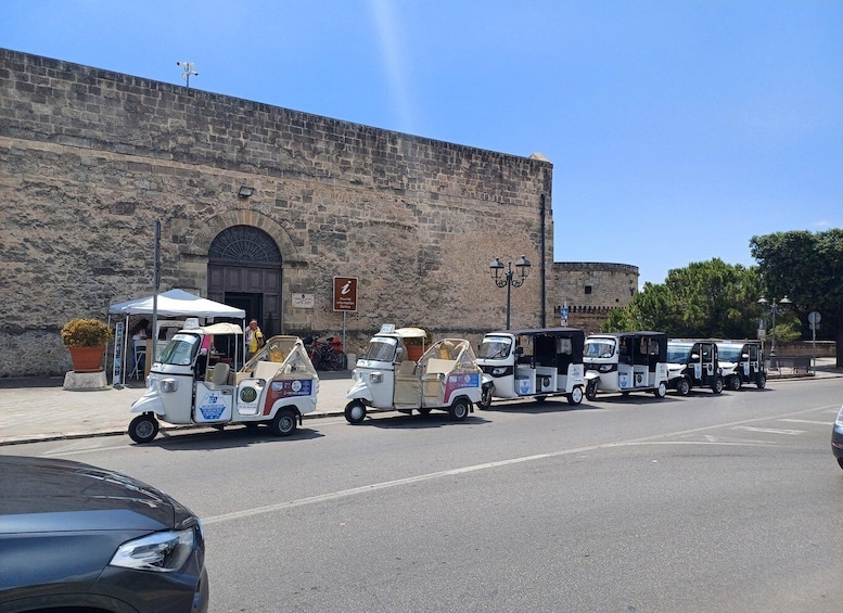 A row of food trucks parked in front of a historic stone building. 4