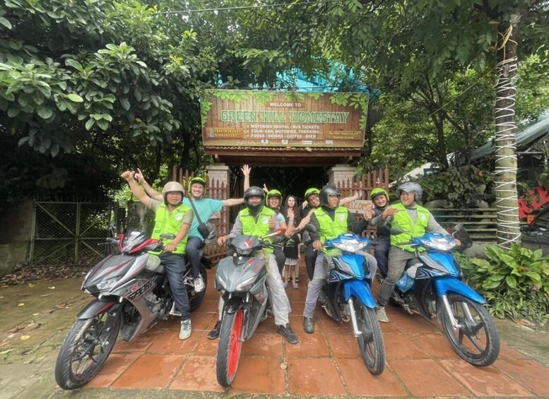 A group of people on motorcycles in front of a sign welcoming to Green Hill Homestay. 5