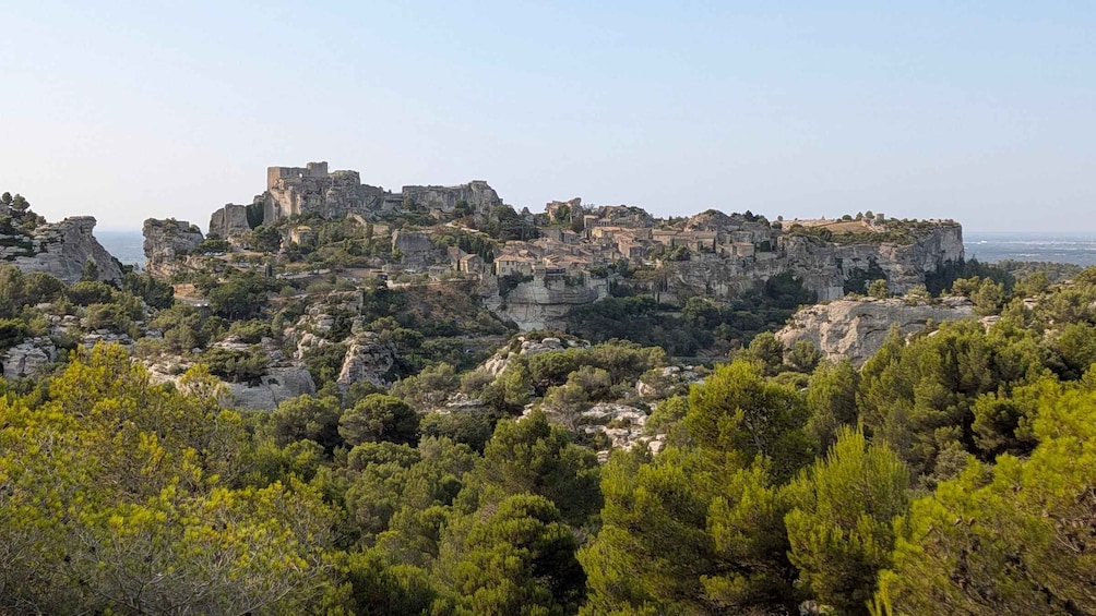 A rugged cliffside with ancient ruins and dense greenery. 1