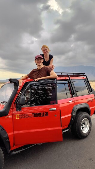 A red off-road vehicle with the text 'NATIONAL GEOGRAPHIC TRAVELLER' on the side. 4