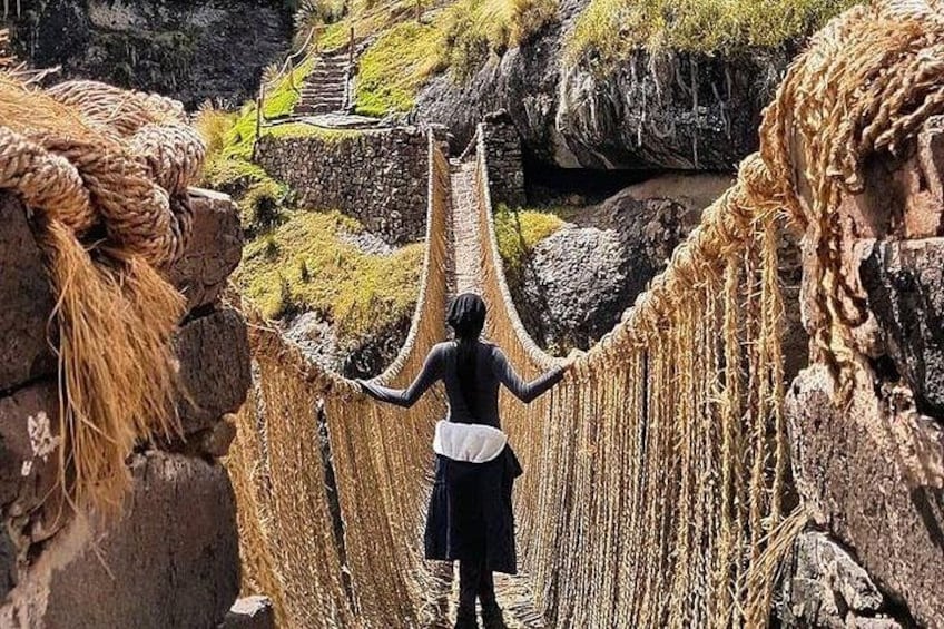 A person crossing a rope bridge over a rocky gorge. 1