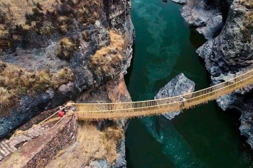 A suspension bridge over a river, surrounded by rocky cliffs. 5