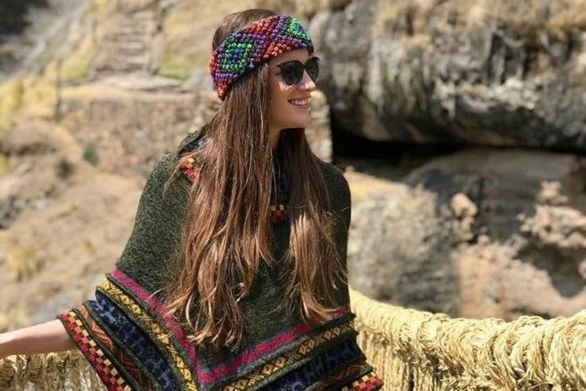 A person sitting on a woven structure outdoors with a rocky landscape in the background. 5