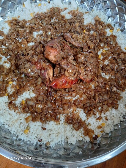 A glass bowl of rice with chicken and onions. 3