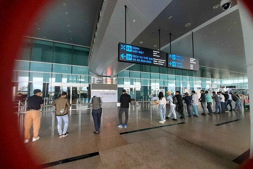 A modern airport terminal with glass walls and directional signs. 4