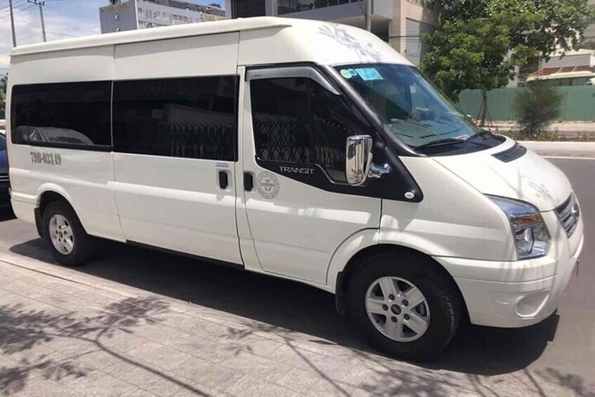 A white van parked on the side of a road with a 'TRANSIT' logo on the side. 3