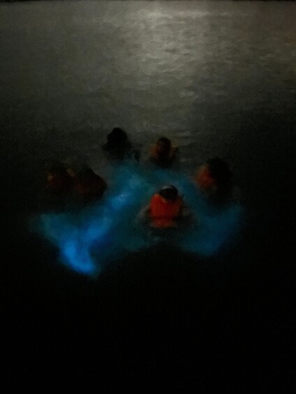 A group of people in a dark, misty environment, possibly a cave or underwater setting. 3