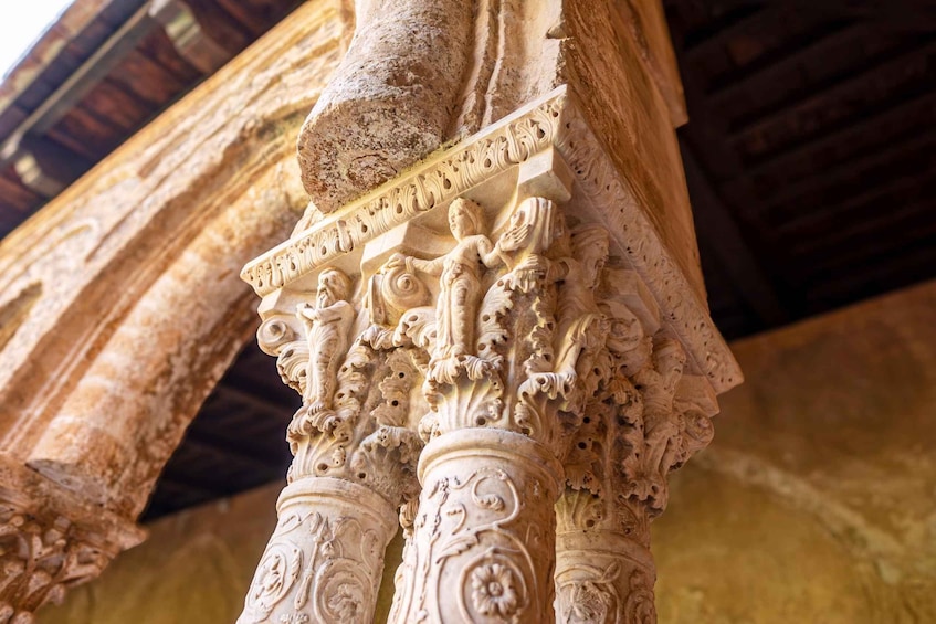 A detailed stone column with intricate carvings and a wooden ceiling structure. 4