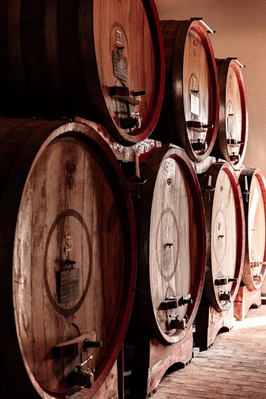 Wooden wine barrels stacked in a warehouse. 5