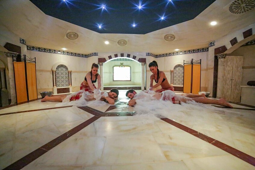 A room with a tiled floor, a central fountain, and decorative ceiling lights. 4