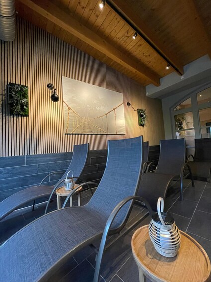 A modern interior with wooden slats on the walls, a large abstract painting, and curved seating with a small table and decorative item. 2