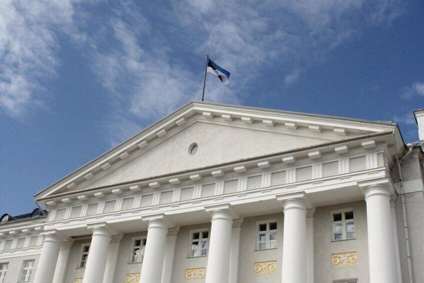 A neoclassical building with columns and a flag. 5