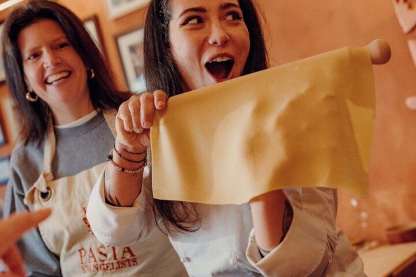 Two people holding a large piece of yellow paper. 3