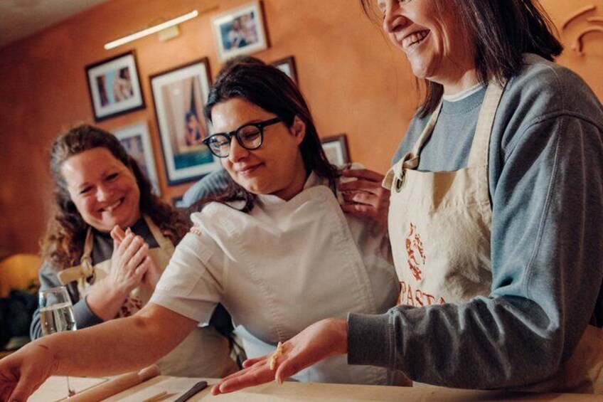 Three people wearing aprons, engaged in a cooking activity. 1