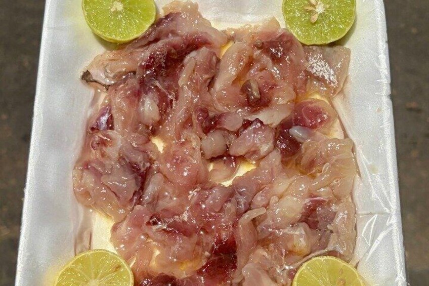 Raw fish fillets on a white tray with lime wedges. 4