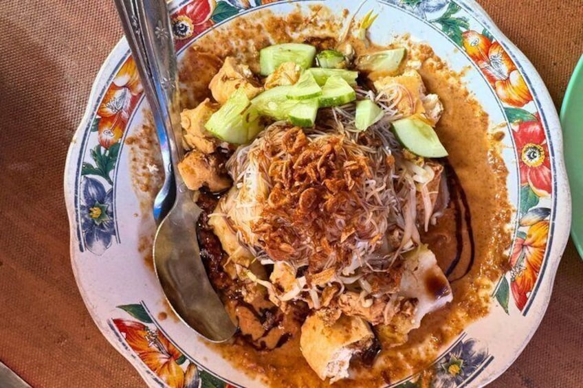 A plate of food with shredded meat, sliced cucumbers, and fried onions. 1