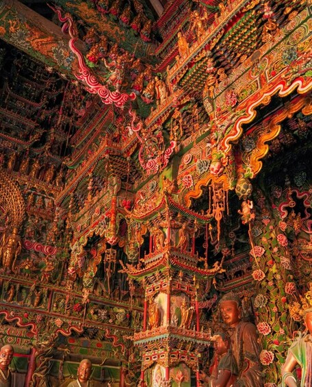 A richly decorated temple interior with intricate carvings, statues, and vibrant colors. 2