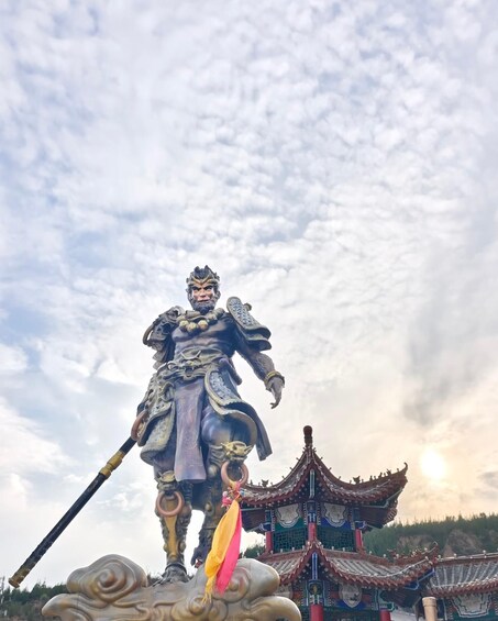 A statue of a warrior with a spear, standing on a cloud-like base, with traditional Chinese architecture in the background. 3