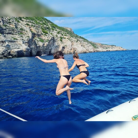 Two people jumping into the sea from a boat. 2