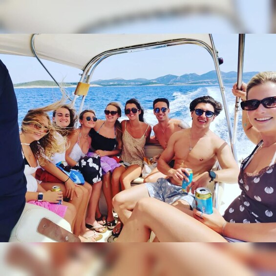 A group of people on a boat with a clear view of the sea and distant land. 3