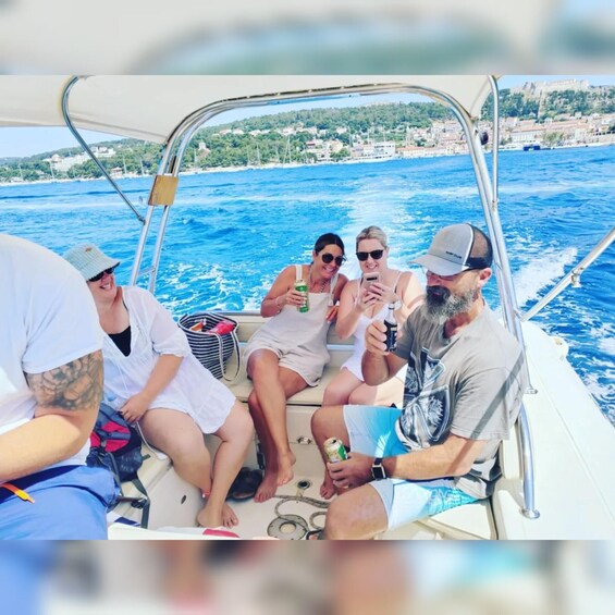 A group of people on a boat with a coastal landscape in the background. 5