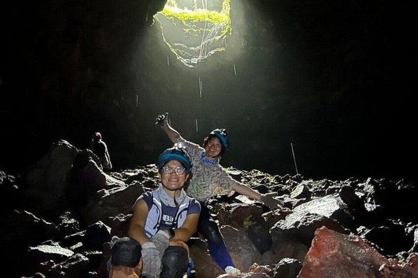 Two people in a rocky cave with a light source above. 2