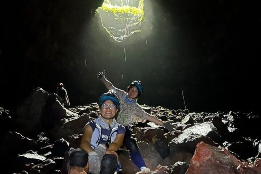 People in a rocky cave with a light source above. 2