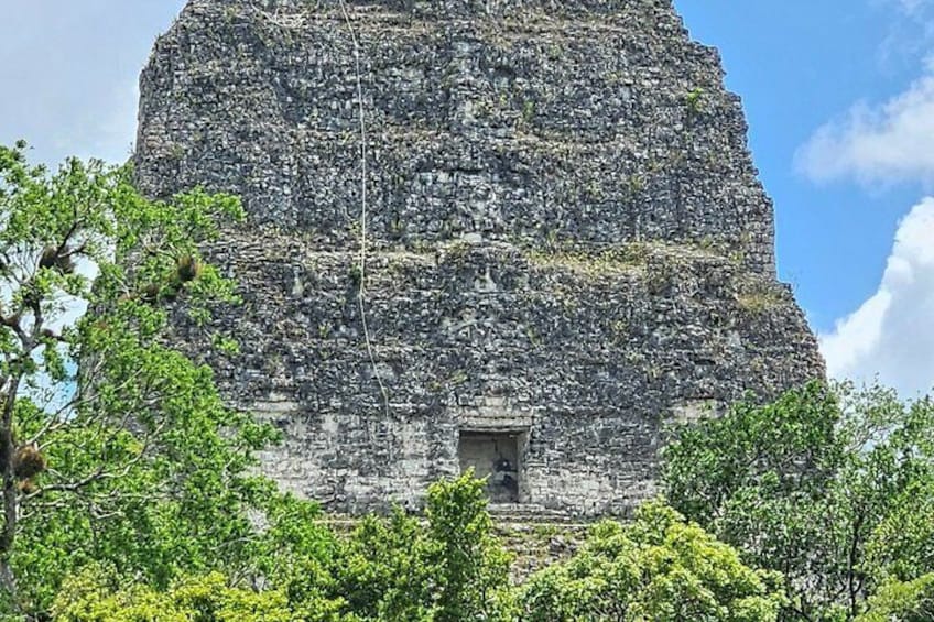 A large, ancient stone structure with a small entrance at the base. 4