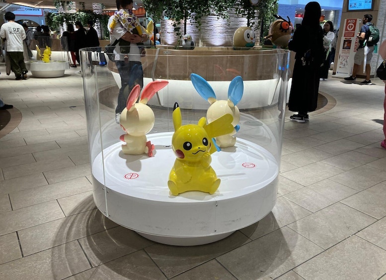 A display of Pokemon plush toys in a glass enclosure. 3