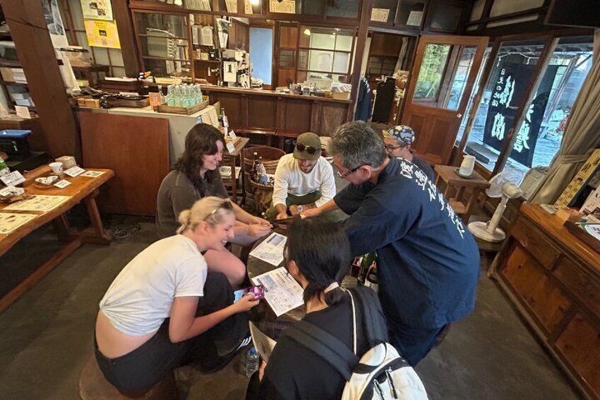 A group of people in a room with wooden furniture and shelves filled with books and papers. 5