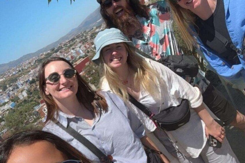 A group of people on a mountain with a cityscape in the background. 4