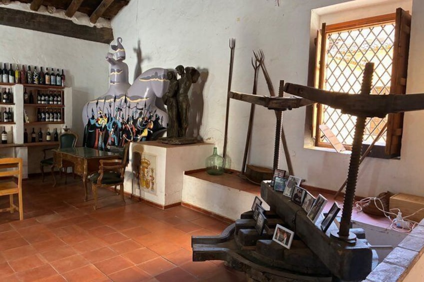 A rustic interior with a dining area, a wine rack, and various tools. 2