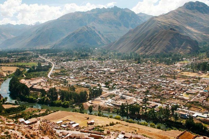 A mountainous landscape with a river, a town, and a mountain range. 3