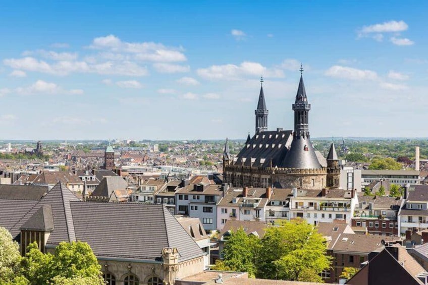 A historic building with two spires, surrounded by a densely packed urban area with various buildings. 1